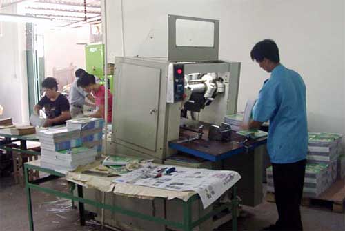 工人用三面切書機裁切書刊